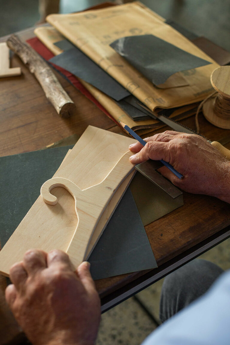 Close-up of hands crafting a handmade wooden hanger for kindergarten use