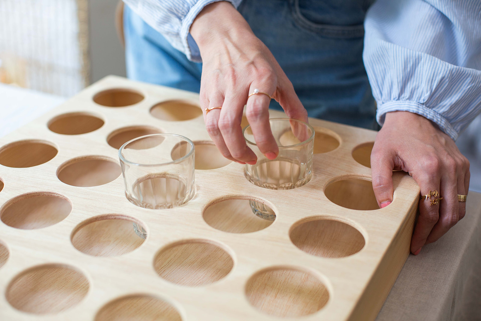 Wooden kindergarten cup holder in use with small glasses for children, demonstrating practical design and aesthetics in classroom environment